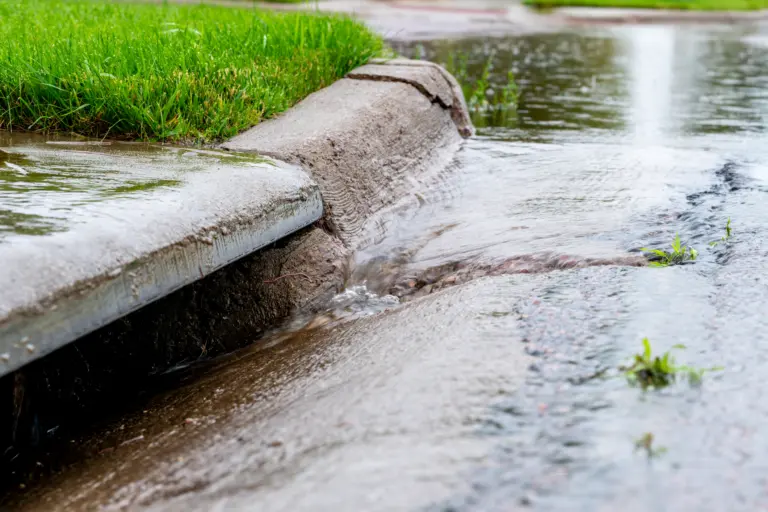 Stormwater flowing into street intake drain after a rainstorm